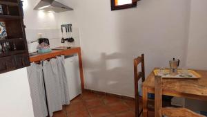 イコー・デ・ロス・ビノスにあるApartamentos-Monasterio-de-San-Antonio-Mediterranes-Apartment-mit-kleiner-Terrasse-im-Innenhofのキッチン(テーブル、冷蔵庫、テーブル、テーブル付)