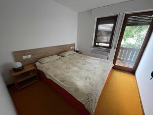 Habitación pequeña con cama y ventana en Appartamento per Famiglie, 6 posti, in centro ad Asiago, en Asiago