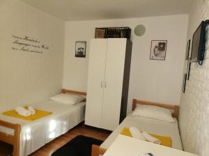 Habitación con 2 camas y armario blanco en Studio Sofia en Novalja