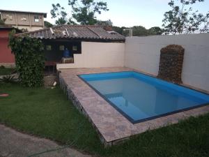 ein Schwimmbad in einem Hof neben einem Haus in der Unterkunft Recanto do cowboy in Vila Velha