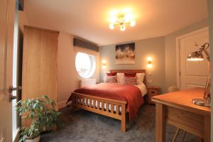 a small bedroom with a bed and a window at Streamside Apartments in Yeovil