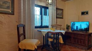 a living room with a table and a television at Apartamentos-Monasterio-de-San-Antonio-Rustikales-Apartment-mit-kleiner-Terrasse-im-Innenhof in Icod de los Vinos