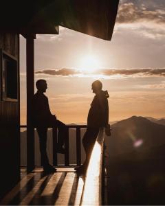 two people standing on a balcony looking at the sunset at Cabañas Casa de Niebla in Pluma Hidalgo
