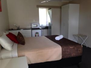 a hotel room with a bed and a desk at Kalua Motel in Bundaberg