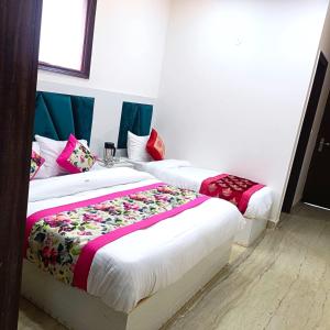 a couple of beds in a room at Hotel Diamond Stay, Nizamuddin Railway Station in New Delhi