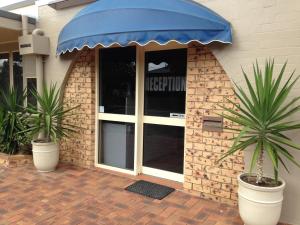 a patio area with an umbrella and a building at Kalua Motel in Bundaberg