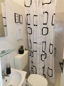 een badkamer met een toilet, een wastafel en een douchegordijn bij Studio Sofia in Novalja