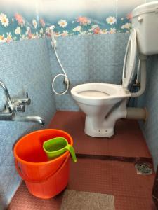 een badkamer met een toilet en een emmer bij Coorg Orange Villa in Madikeri