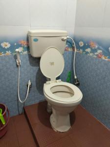 een badkamer met een toilet met een slang bij Coorg Orange Villa in Madikeri