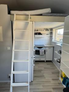 a bunk bed with a ladder in a room at Atterfallshus1 in Nyköping