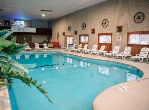 uma grande piscina com cadeiras brancas num quarto em Carriage House Country Club em Pocono Manor