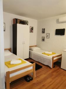 Habitación con 2 camas y armario blanco en Studio Sofia, en Novalja