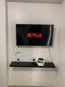 a television on a wall with a netflix sign on it at Condotel at Mesavirre Bacolod City in Bacolod