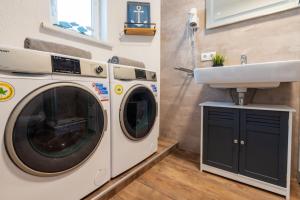 a laundry room with a washing machine and a sink at Strand und Ferienhaus ,,INGER'' mit Terrasse in Rappin