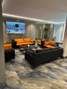 النظافه والجوده في الرياض: غرفة معيشة مع كنب ووسائد برتقال