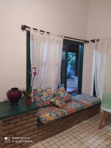 een bed in een woonkamer met een raam bij Ilha , Vera Cruz, Cacha Pregos um lugar lindo e tranquilo ! in Vera Cruz de Itaparica