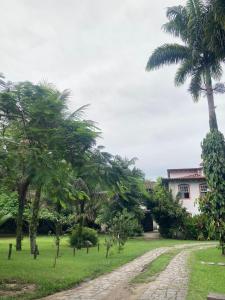uma casa com palmeiras e uma estrada de terra em CASA EM PARATY - EXCELENTE LOCALIZAÇÃO em Paraty