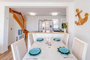 a kitchen and dining room with a white table and chairs at Strand und Ferienhaus ,,INGER'' in Rappin