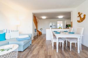 a living room with a white table and a blue couch at ,,Haus INGER'' idyllische Doppelhaushälfte am Banzelvitzer Strand in Rappin