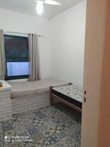 a small bedroom with a bed and a window at Ilha , Vera Cruz, Cacha Pregos um lugar lindo e tranquilo ! in Vera Cruz de Itaparica
