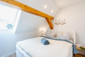 a bedroom with a white bed with a window at Strand und Ferienhaus ,,INGER'' in Rappin