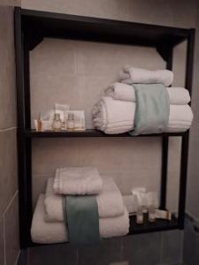 un tas de serviettes sur une étagère dans une salle de bain dans l'établissement Tasinanta casa vacanze, à Santa Luria