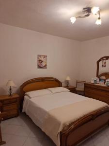 1 dormitorio con 1 cama grande y 2 mesitas de noche en Tasinanta casa vacanze, en Santa Luria
