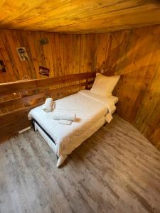 una cama en una habitación con paredes de madera en La Cabane Tonneau - Les Pieds dans le Pré, en Les Landes-Génusson 8 fotos más