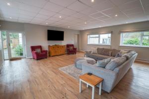 a living room with a couch and a flat screen tv at Bedingfield House, nr Debenham in Debenham