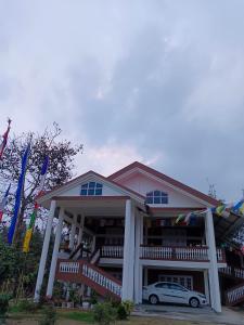 a building with a car parked in front of it at Tsering's Homestay Oyan in Pāsighāt