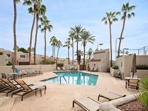 a pool with chaise lounge chairs and palm trees at Scottsdale - 6206 N 30th Pl in Phoenix