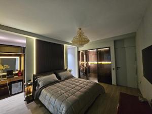 ティラナにあるBlloku Suites, City Centre,Tiranaのベッドルーム1室(大型ベッド1台、シャンデリア付)