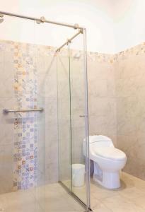 a bathroom with a toilet and a glass shower at Casas Campestres Los Miradores de Fruworld in Carmen de Apicalá