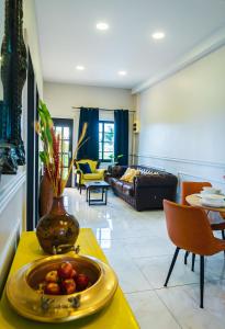 una sala de estar con una mesa amarilla con un tazón de tomates en Cozy and quirky Wolf Apartment, en Paramaribo