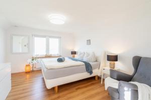 a white bedroom with a bed and a couch at Strand und Ferienhaus ,,MARSI'' am Wasser in Rappin