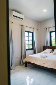Un dormitorio con una cama y dos ventanas en Cozy and quirky Wolf Apartment, en Paramaribo