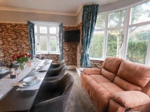 uma sala de estar com uma mesa longa e um sofá em Stakesby Villa Whitby em Whitby