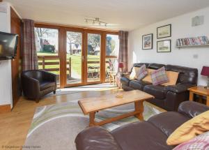 a living room with a couch and a table at Chalet Seventeen in Deal
