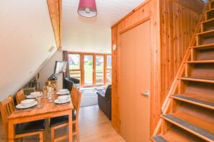 a dining room with a wooden table and a staircase at Chalet Seventeen in Deal