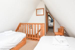 a attic bedroom with two beds and a staircase at Chalet Seventeen in Deal +24 photos