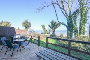 a wooden deck with a table and chairs and a picnic table at Chalet Seventeen in Deal