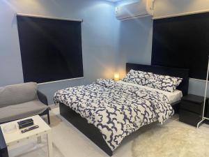 a bedroom with a bed with a black and white comforter at Cozy Room in Jeddah