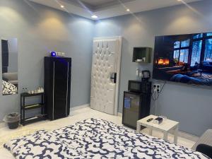 una camera con letto e TV a parete di Cozy Room a Gedda