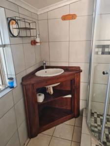 a bathroom with a wooden sink and a shower at Home Sweet Home in Polokwane