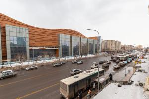 una calle de la ciudad llena de tráfico frente a un edificio en Золотой квадрат, en Astana