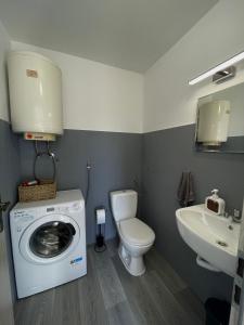 uma casa de banho com uma máquina de lavar roupa e um lavatório em Anamaria em Kaštela