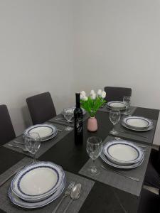 stół z talerzami i kieliszkami oraz butelkę wina w obiekcie Anamaria w mieście Kaštela