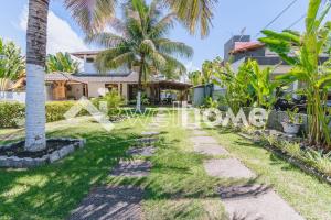 una pasarela frente a una casa con palmeras en Casa a 5 minutos das Piscinas Naturais em Alagoas en Paripueira