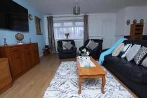 a living room with a couch and a coffee table at Beautiful 4-Bed House in Erith in Erith