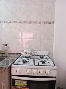 uma placa de fogão branca na cozinha em La Coplera em Cachí